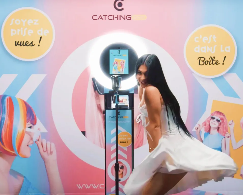 Femme posant devant un photobooth Catchingbox lors d'un événement