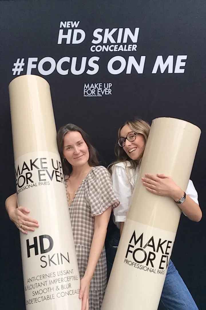 Deux invitées posant avec des accessoires géants au photobooth Catchingbox pour le lancement du HD Skin Concealer de Make Up For Ever