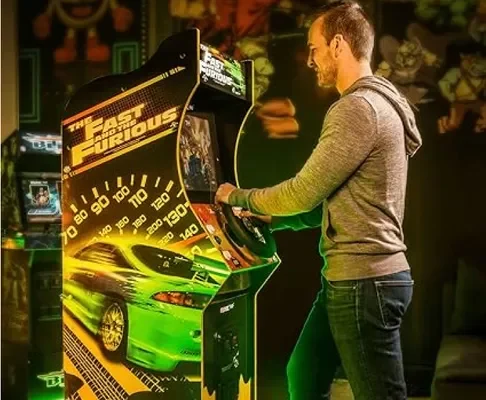 Homme jouant sur une borne d'arcade The Fast & The Furious de Catchingbox